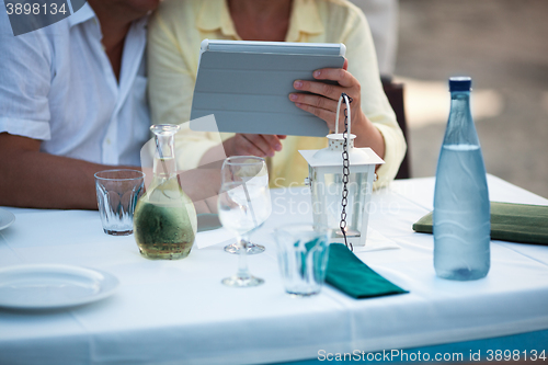 Image of Middle-aged couple using a tablet at the table