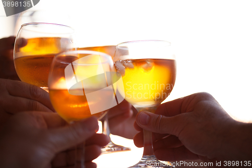 Image of Several people clinking glasses with cold drinks