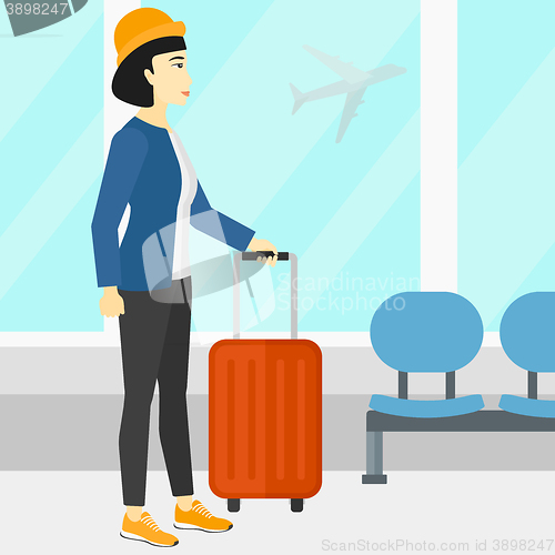 Image of Woman at airport with suitcase.