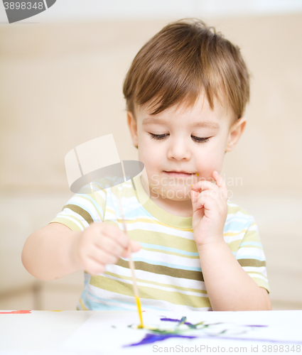 Image of Little boy is playing with paints