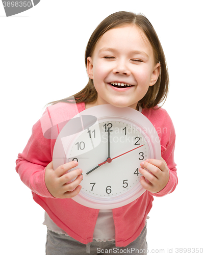 Image of Little girl is holding big clock