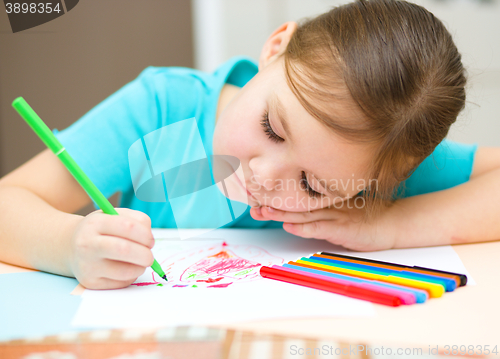 Image of Cute cheerful child drawing using felt-tip pen