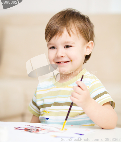 Image of Little boy is playing with paints