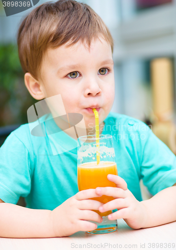 Image of Little boy with glass of orange juice