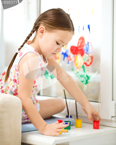 Image of Portrait of a cute girl playing with paints