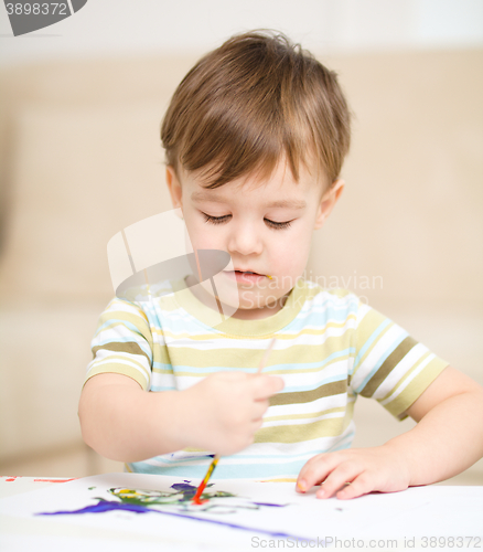 Image of Little boy is playing with paints