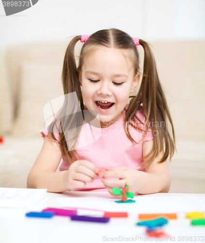 Image of Little girl is playing with plasticine