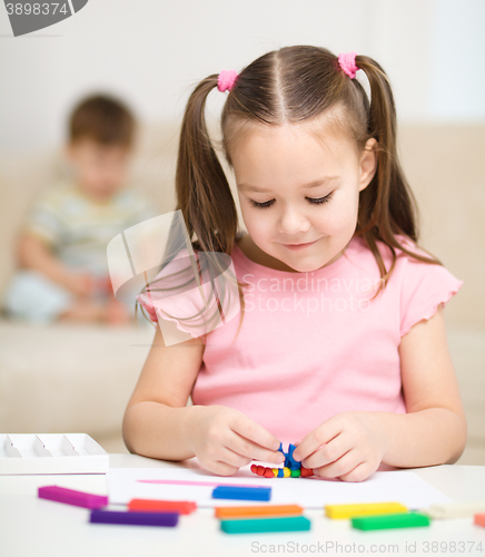 Image of Little girl is playing with plasticine