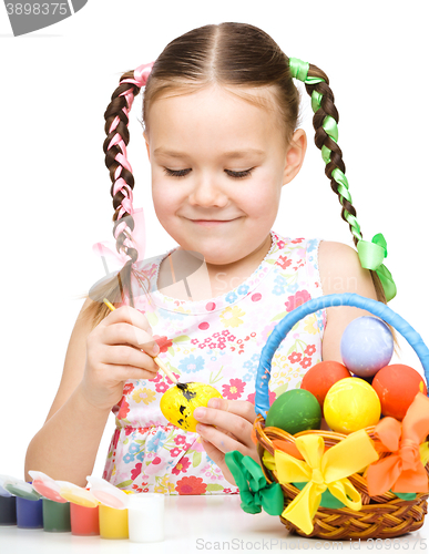 Image of Little girl is painting eggs preparing for Easter