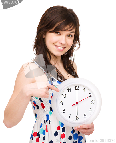 Image of Young woman is holding big clock