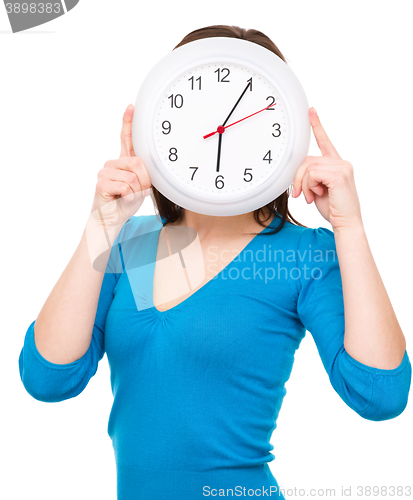 Image of Young woman is holding big clock