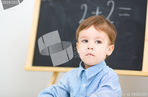 Image of Little boy is sitting on math lesson