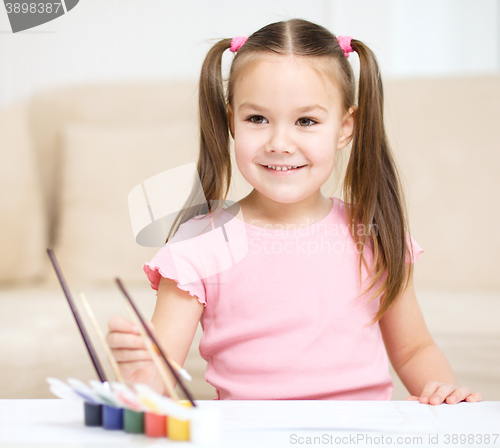 Image of Cute cheerful child play with paints