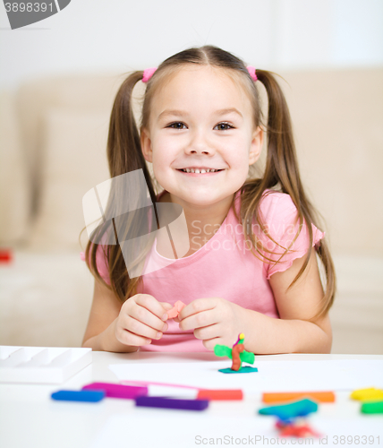 Image of Little girl is playing with plasticine