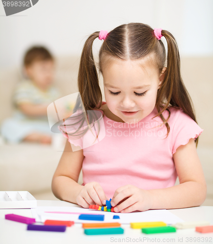 Image of Little girl is playing with plasticine