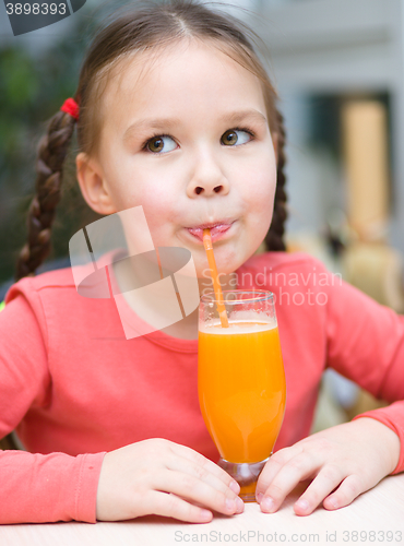 Image of Little girl is drinking orange juice