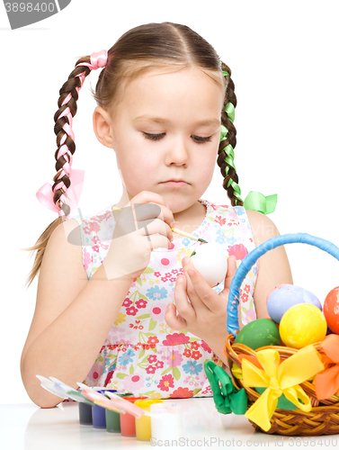 Image of Little girl is painting eggs preparing for Easter