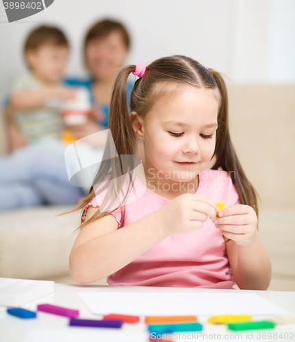 Image of Little girl is playing with plasticine