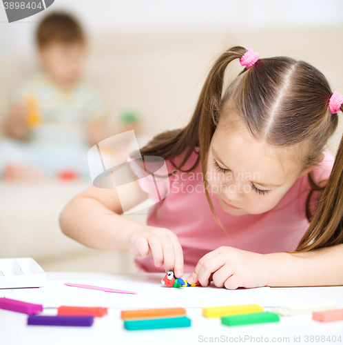 Image of Little girl is playing with plasticine