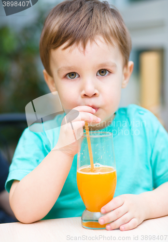 Image of Little boy with glass of orange juice