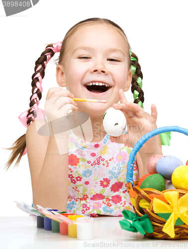 Image of Little girl is painting eggs preparing for Easter