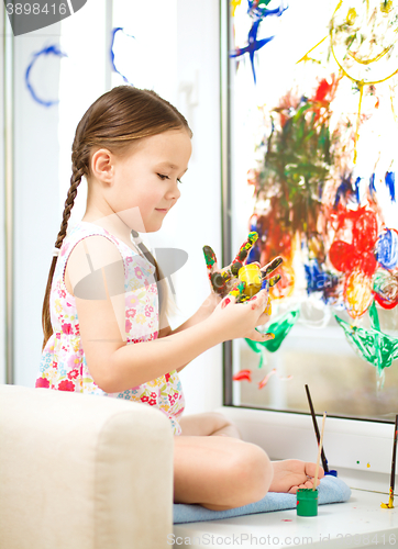 Image of Portrait of a cute girl playing with paints