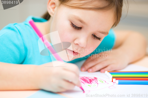 Image of Cute cheerful child drawing using felt-tip pen