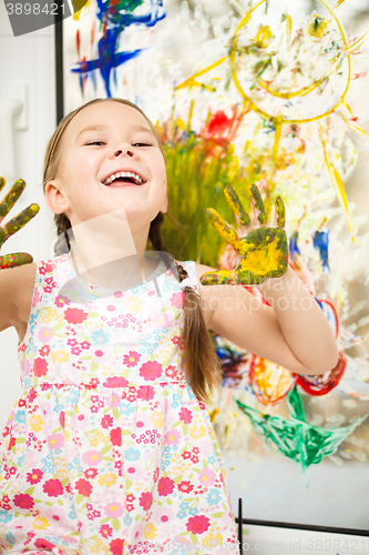 Image of Portrait of a cute girl playing with paints