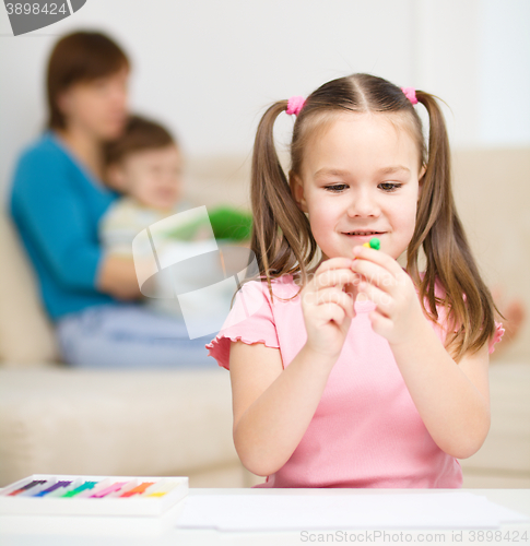 Image of Little girl is playing with plasticine