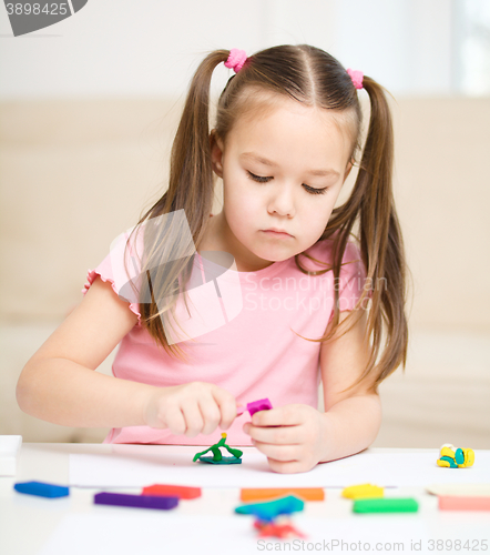 Image of Little girl is playing with plasticine