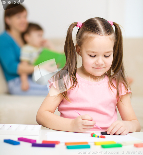 Image of Little girl is playing with plasticine