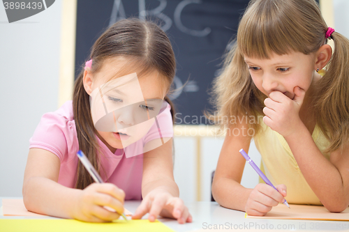 Image of Little girls are writing using a pen