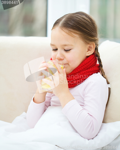 Image of Ill little girl is drinking vitamin cocktail