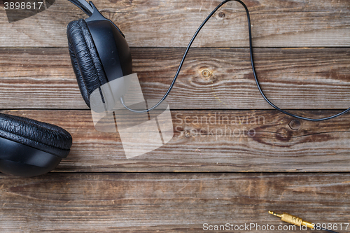 Image of Headphones over wooden table.