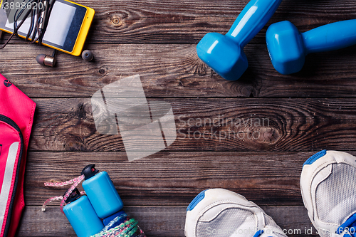 Image of Sports equipment - sneakers, skipping rope, dumbbells, smartphone and headphones. 