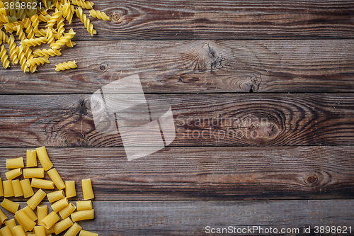 Image of Mixed dried pasta selection on wooden background.