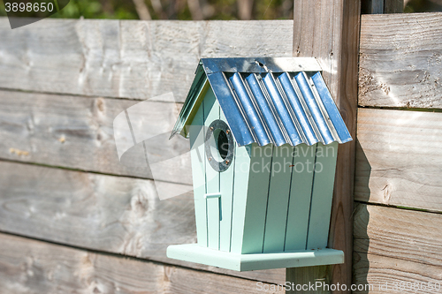 Image of Cute birdhouse hanging on a fence