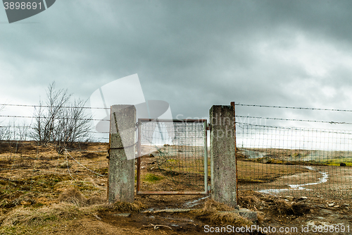 Image of Broken gate on a field with barb wire