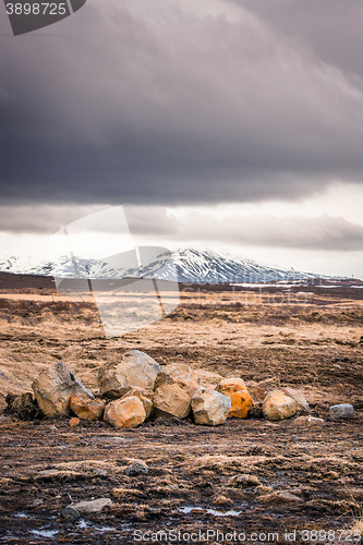 Image of Field with rocks and mountains