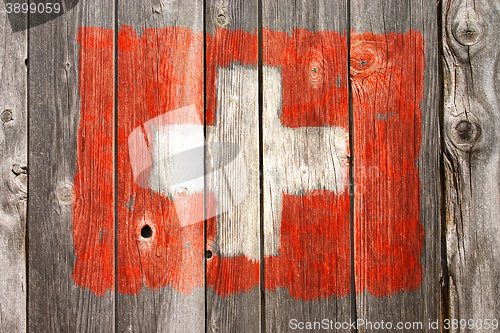 Image of swiss colors on old wooden wound