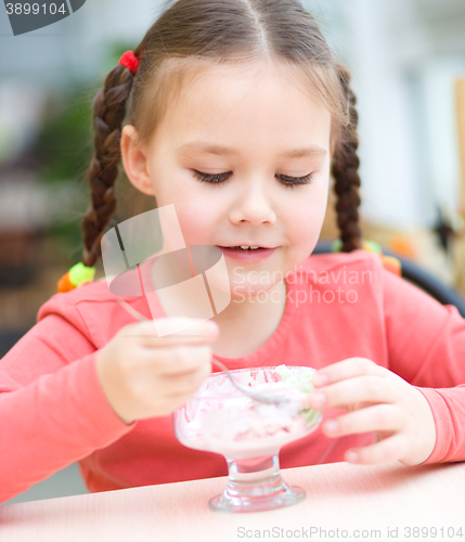 Image of Little girl is eating ice-cream in parlor