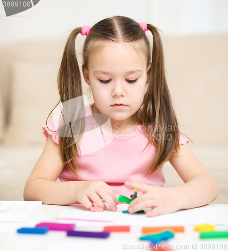 Image of Little girl is playing with plasticine