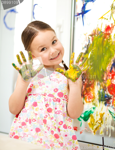 Image of Portrait of a cute girl playing with paints