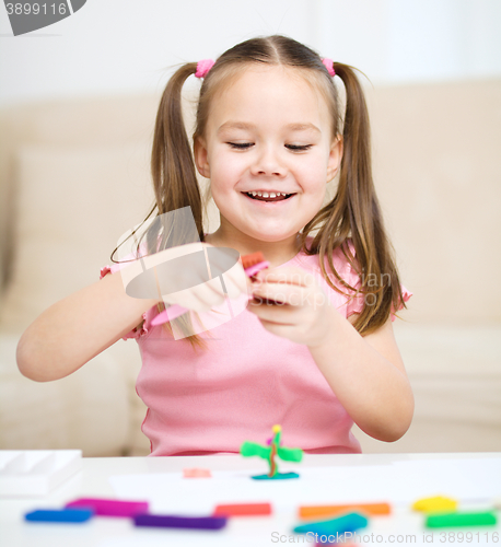 Image of Little girl is playing with plasticine