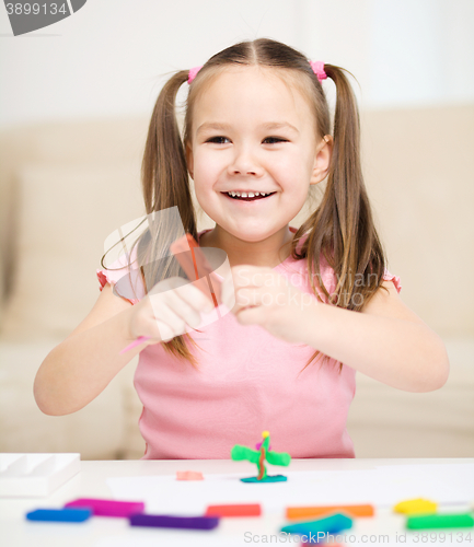 Image of Little girl is playing with plasticine