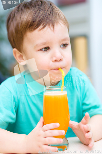 Image of Little boy with glass of orange juice