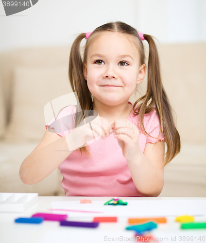 Image of Little girl is playing with plasticine