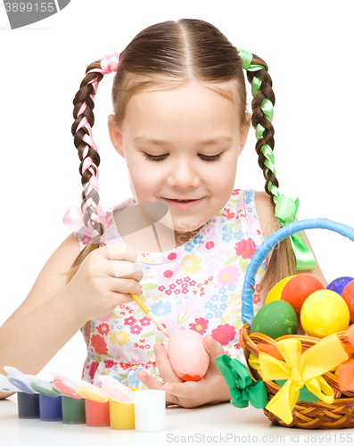 Image of Little girl is painting eggs preparing for Easter