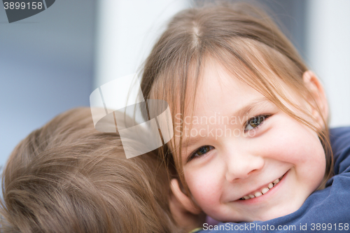 Image of Little girl is embracing her brother