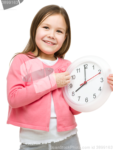 Image of Little girl is holding big clock